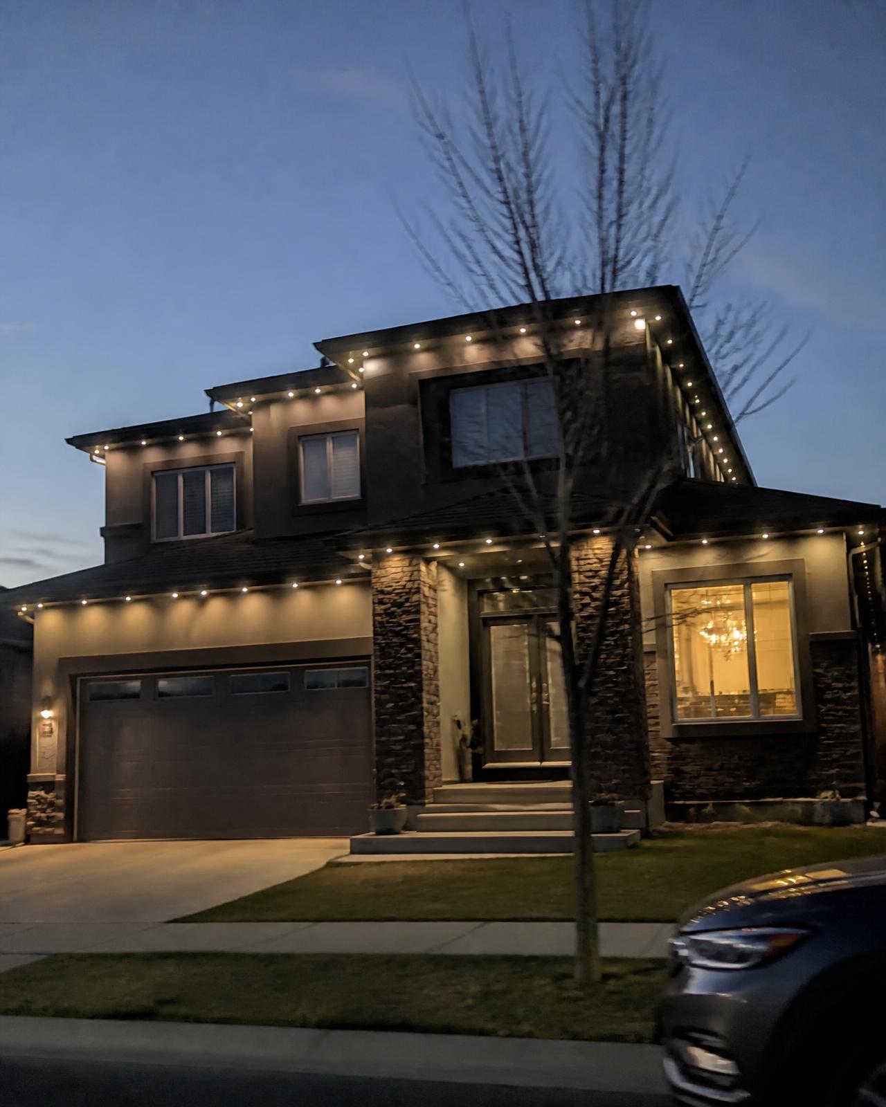 Contemporary luxury home at night with permanent roofline lighting