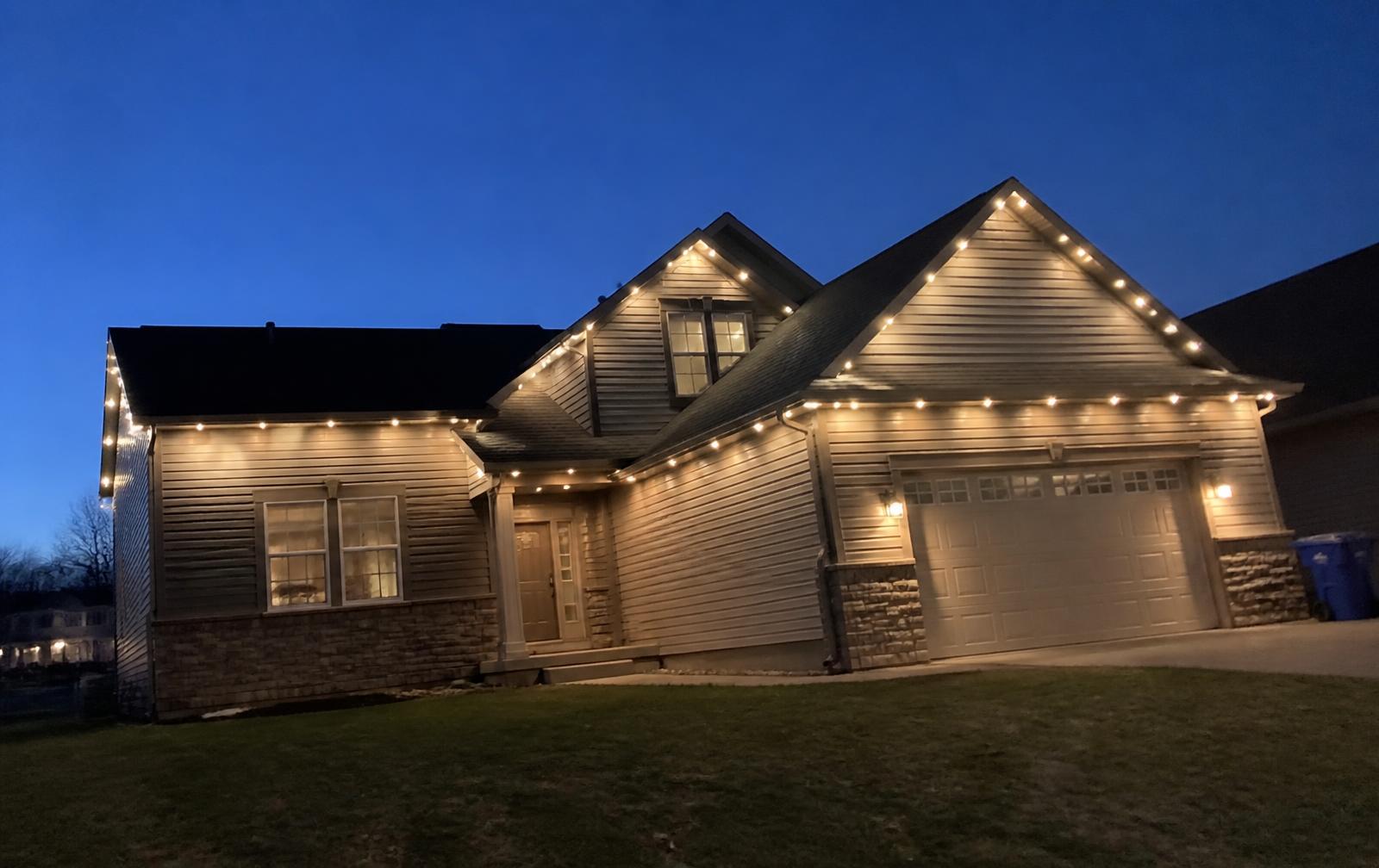 Suburban family home at dusk with permanent architectural lighting