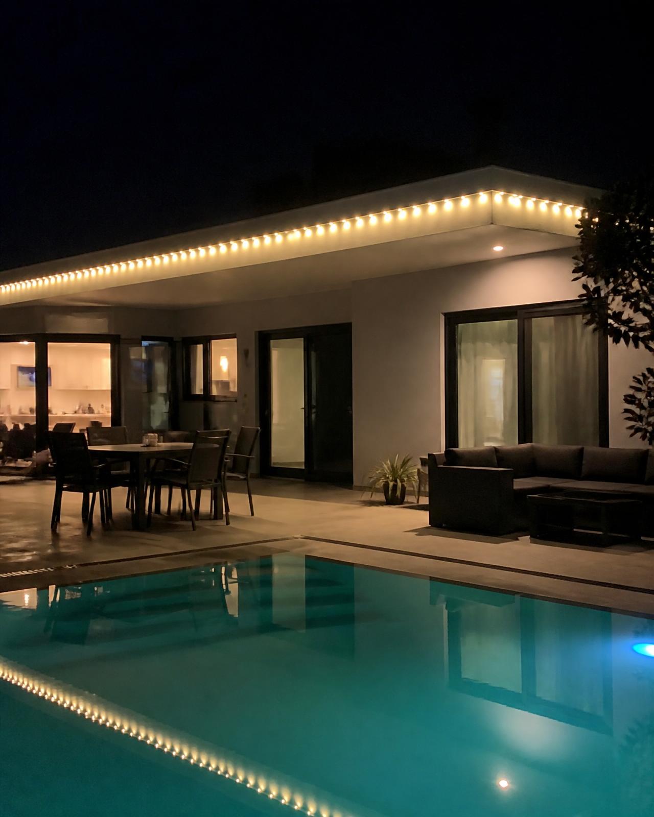 Minimalist modern home with lighting reflected in a pool