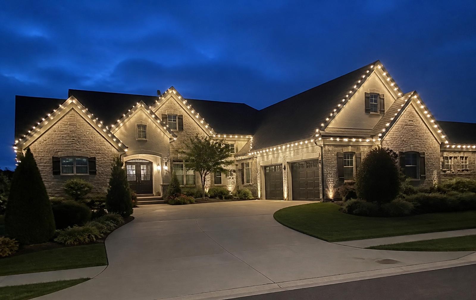 Large estate home with every roofline illuminated at dusk